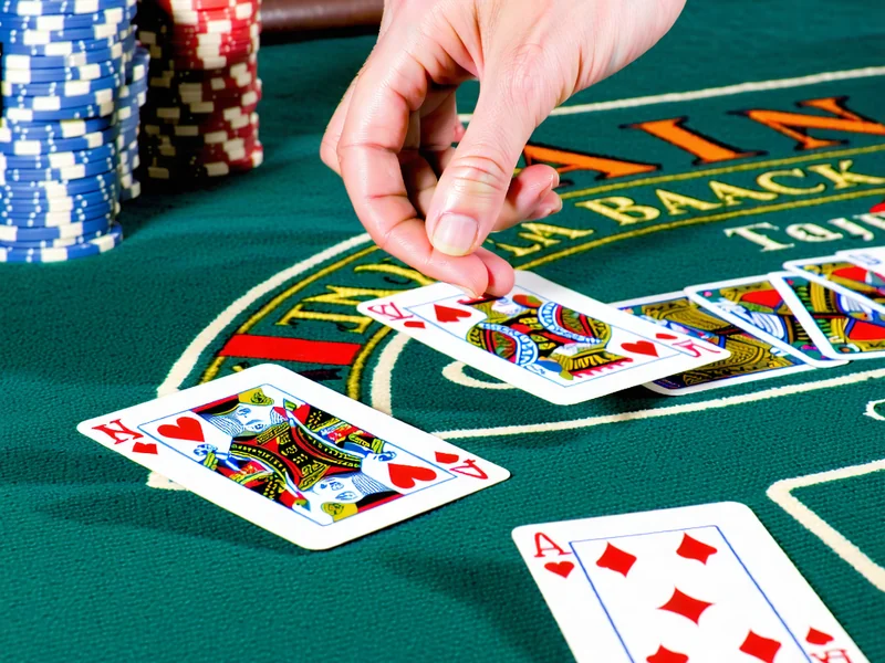 Hình ảnh bàn Blackjack với người chia bài và người chơi đang đặt cược tại i9bet